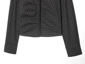 Detailed view of the dark grey plaid fabric and ruched texture on the slim fit top