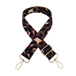 Macro view of leopard print nylon bag strap with polished gold hardware buckles