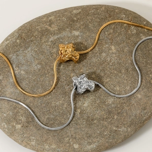 Modern gold and silver irregular geometric lava pendant necklaces on natural stone