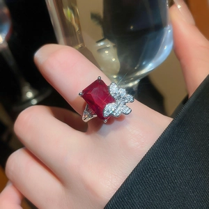 Close-up of elegant red rectangle gemstone ring with detailed diamond butterfly motif