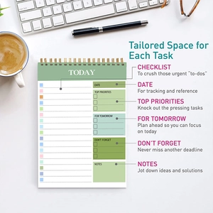 Flat lay of light green daily planner with checklist sections on tidy office desk