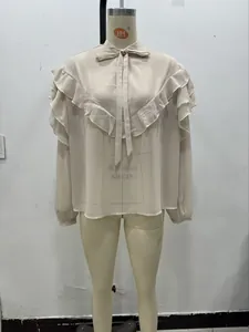 Detailed view of layered ruffles and elegant bow tie neckline on a beige chiffon blouse