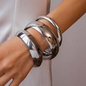 Close-up of three pieces set glossy silver metal geometric round bangles for women