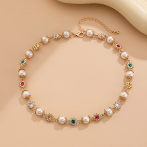 Détail du collier de perles et pierres précieuses colorées avec chaîne dorée sur fond beige