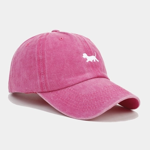 Détail de casquette vintage en coton délavé rose rouge avec broderie de chien blanc