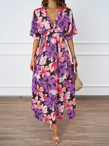 Detailaufnahme des tiefen V-Ausschnitts an einem lila Maxikleid mit Blumenmuster