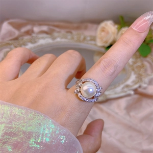 Macro shot of an elegant pearl ring featuring a large white pearl and zircon accents