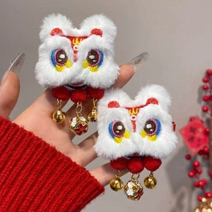 Detailed close-up of fluffy Chinese lion hair clips with colorful embroidery and golden bells