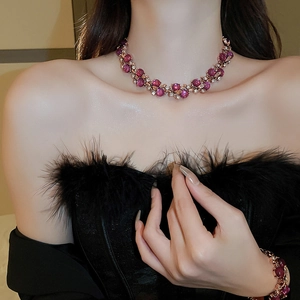 Detailed close-up of golden necklace and bracelet set with purple gems and rhinestones