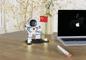 Macro detail of astronaut building block figure with LED light base and flag on desk