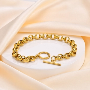 Detail of a minimalist gold stainless steel pearl bracelet with a stylish OT toggle clasp