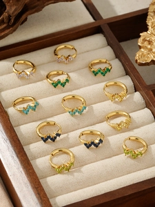 Detail view of 18k gold hoop earrings with multi-colored cubic zirconia in a jewelry box