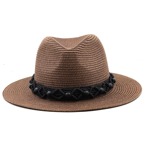 Detail of brown straw fedora featuring a black woven band with circular bead accents