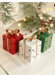 Trois boîtes cadeaux en métal en forme d'étoile aux couleurs rouge, blanc et vert festif