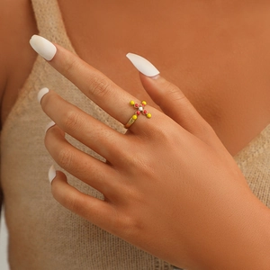 Adjustable gold titanium cross ring with colorful resin beads worn by a model