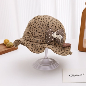 Macro detail of floral baby bucket hat featuring a polka dot bow and lace trim