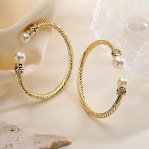 Eleganter goldener gedrehter Armreif mit weißen Perlen und funkelnden Zirkonia-Akzenten