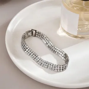 Elegant silver triple-row tennis bracelet with white sparkling crystals on a ceramic tray