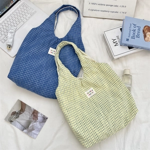Gros plan de sacs fourre-tout à carreaux bleus et jaunes avec étiquettes sur tissu doux