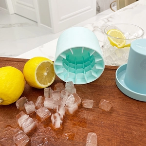 Light blue silicone ice cube maker bucket with lid on wooden board with fresh lemons