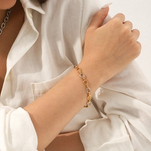 Minimalist gold and silver two-tone mixed chain link bracelet worn on a woman's wrist
