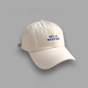 Close-up of blue 'HELLO WEEKEND' embroidery on a beige cotton baseball cap with curved brim