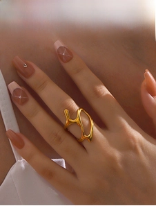 Detailed view of irregular hollow gold ring with flowing organic lines on finger