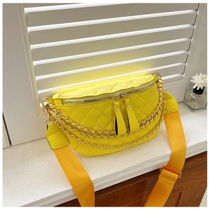 Detail of yellow quilted chest bag with triple gold chains and orange woven strap