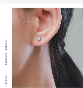 Close-up of a S925 silver stud earring with a round-cut zircon on a model's ear