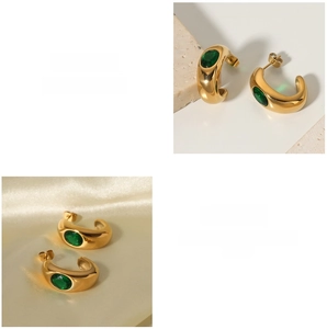 Close-up of 18K gold plated C-shaped earrings with inlaid green oval zircon stones