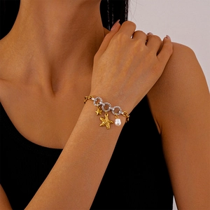 Detailed shot of ocean-themed bracelet with gold starfish charms and white pearl