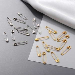Flat lay of multiple gold and silver 18K plated metal safety pins for garments