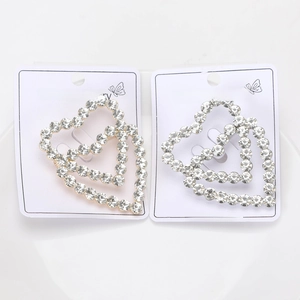 Macro shot of sparkling hollow heart stud earrings in gold and silver plating