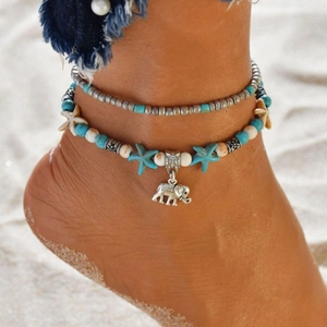 Bohemian multi-layer anklet with turquoise beads, starfish and elephant charms on sandy beach
