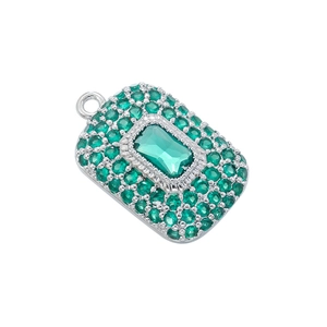 Macro shot of silver pendant with pave green crystals and a large emerald-cut centerpiece