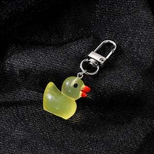 Close-up of a translucent yellow resin duck keychain with a polished silver metal clasp