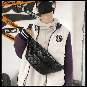 Detail of black quilted crossbody waist bag featuring nylon material and adjustable strap