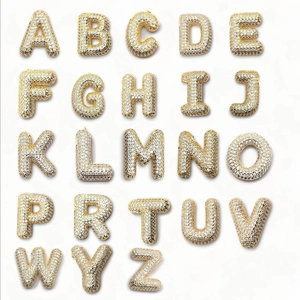 Détail des pendentifs lettres 3D en plaqué or 18 carats avec zircons micro-pave