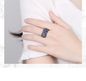 Macro detail of black gold ring with colorful micro-pave zircons worn on finger