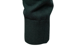 Detail of dark green knit sweater featuring a ribbed cuff and high-quality fabric texture