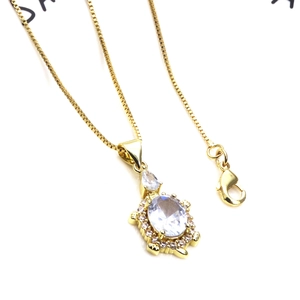 Macro shot of gold turtle necklace featuring oval clear zircon and sparkling crystals