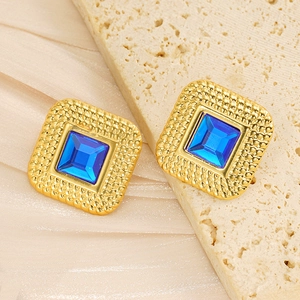 Close-up of vintage square blue acrylic earrings with 18k gold plated textured frame