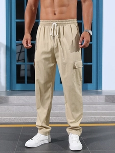 Detail of khaki cargo pants with drawstring waist and flap pockets on casual model