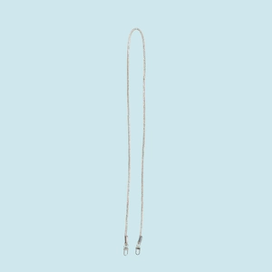 Macro view of silver rhinestone strap with metal lobster clasps on light blue background