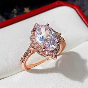 Macro shot of rose gold S925 ring with oval cubic zirconia and halo diamond setting