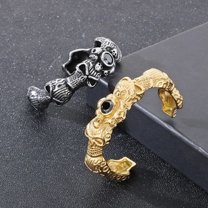 Detail of gothic skull bracelets with black zircon stones and metal flame embossing