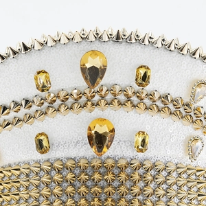 Detail of gold sequins with metallic spikes and amber rhinestones on a festival hat