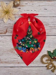 Flat lay of red Christmas pet bandana with holiday patterns on white wooden background