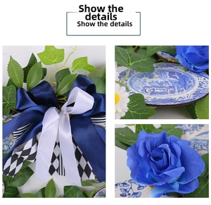 Close-up of blue silk roses, porcelain pattern ornaments and ribbon details on a floral wreath