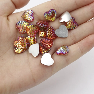Macro shot of 12mm heart-shaped resin cabochons with iridescent mermaid fish scale texture